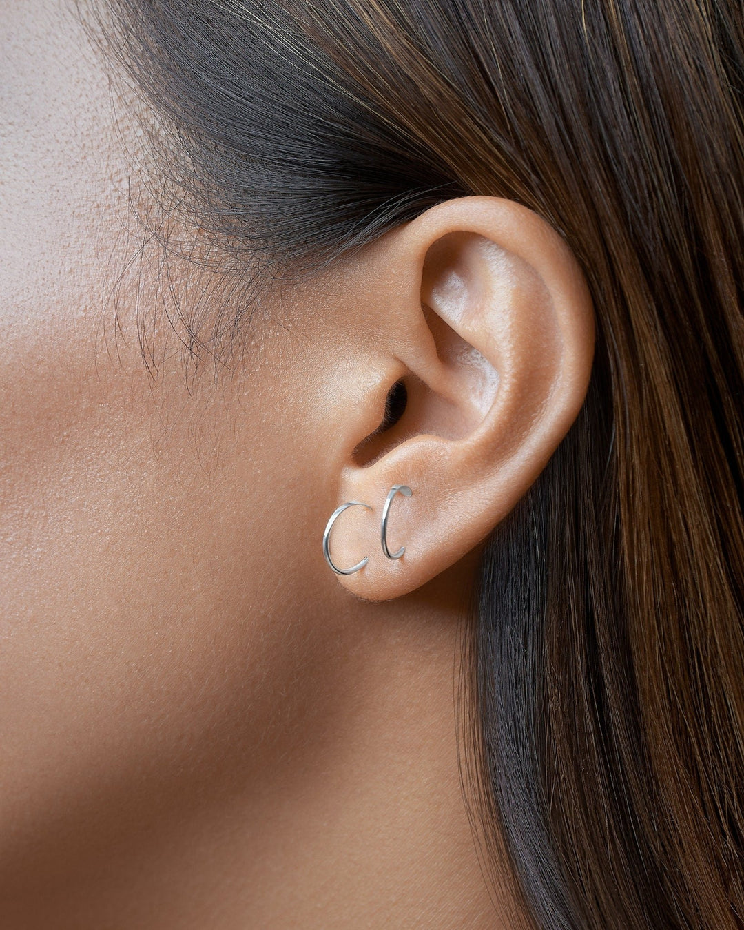 Gold Noe hammered hoop earring worn — close-up showing soft curve and elegant shine in real wear.