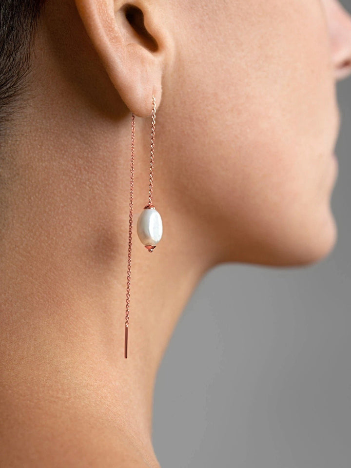 Rose gold threader earring with freshwater pearl worn — sophisticated and luminous look on ear.
