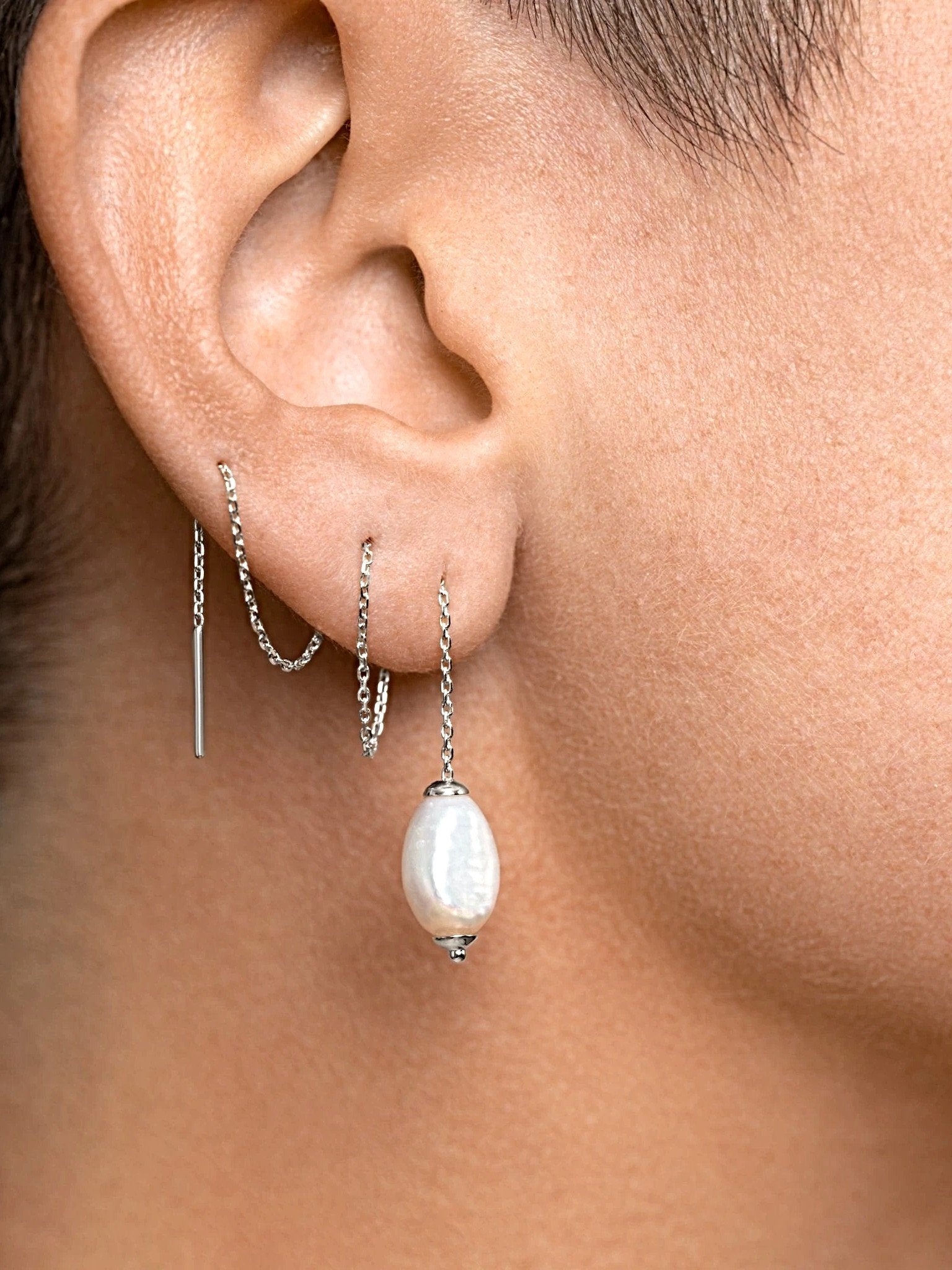 Silver threader pearl earring worn — modern and elegant jewelry design with natural pearl accent.
