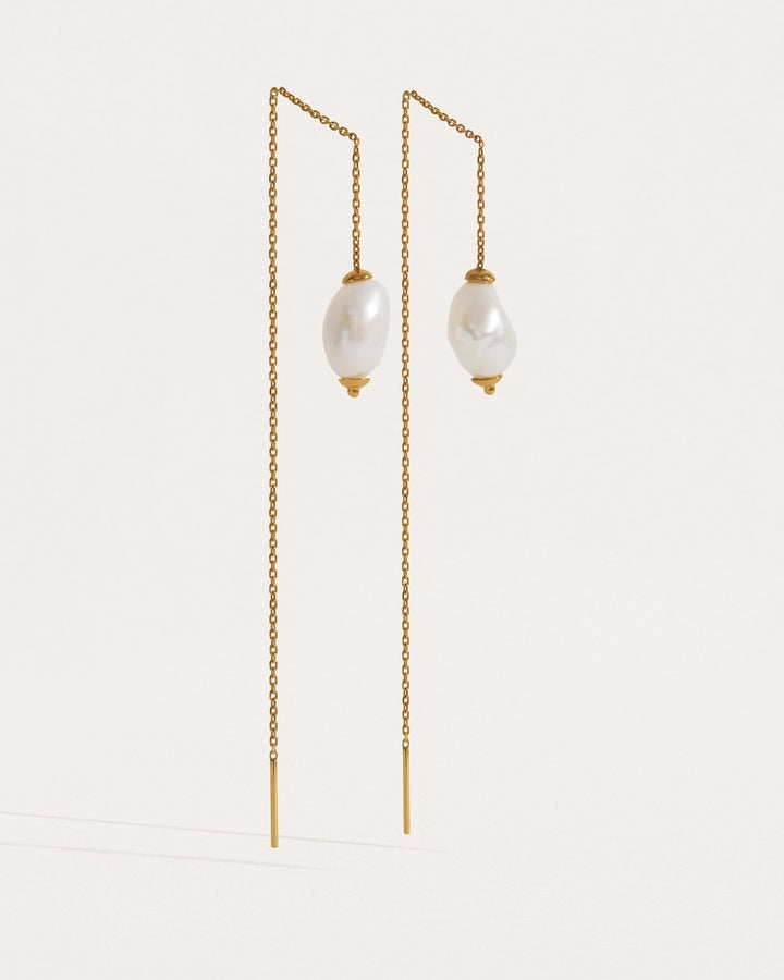 Two pairs of threader earrings in silver and gold finishes — freshwater pearl drops on fine chain.