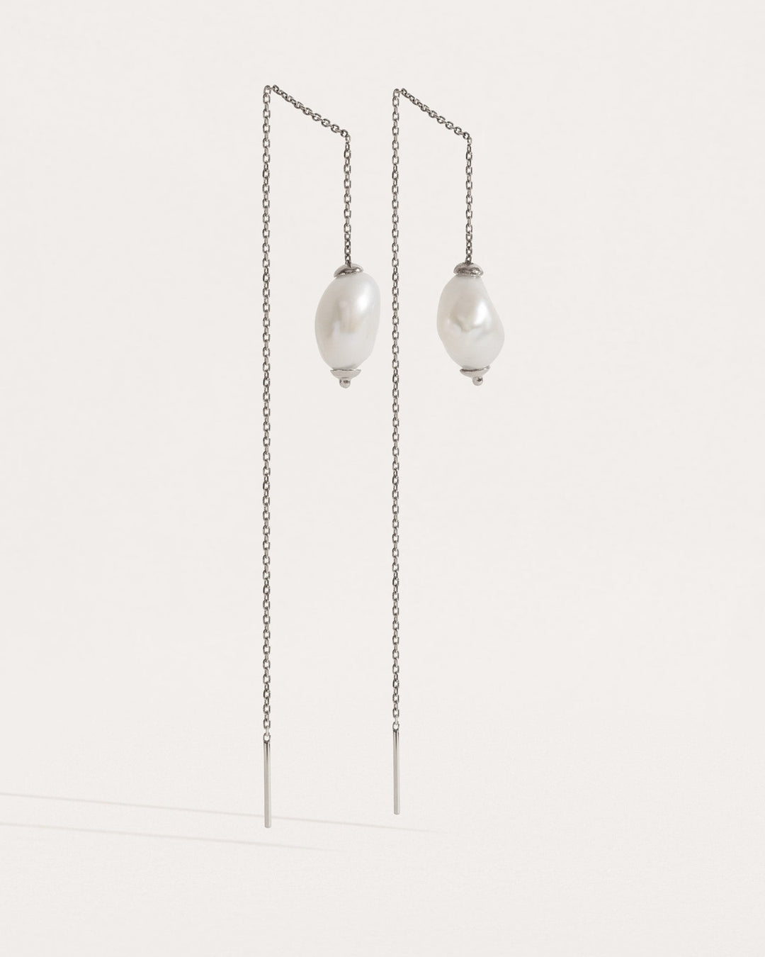 Front-facing view of threader earrings in sterling silver — minimalist chain with freshwater pearls.