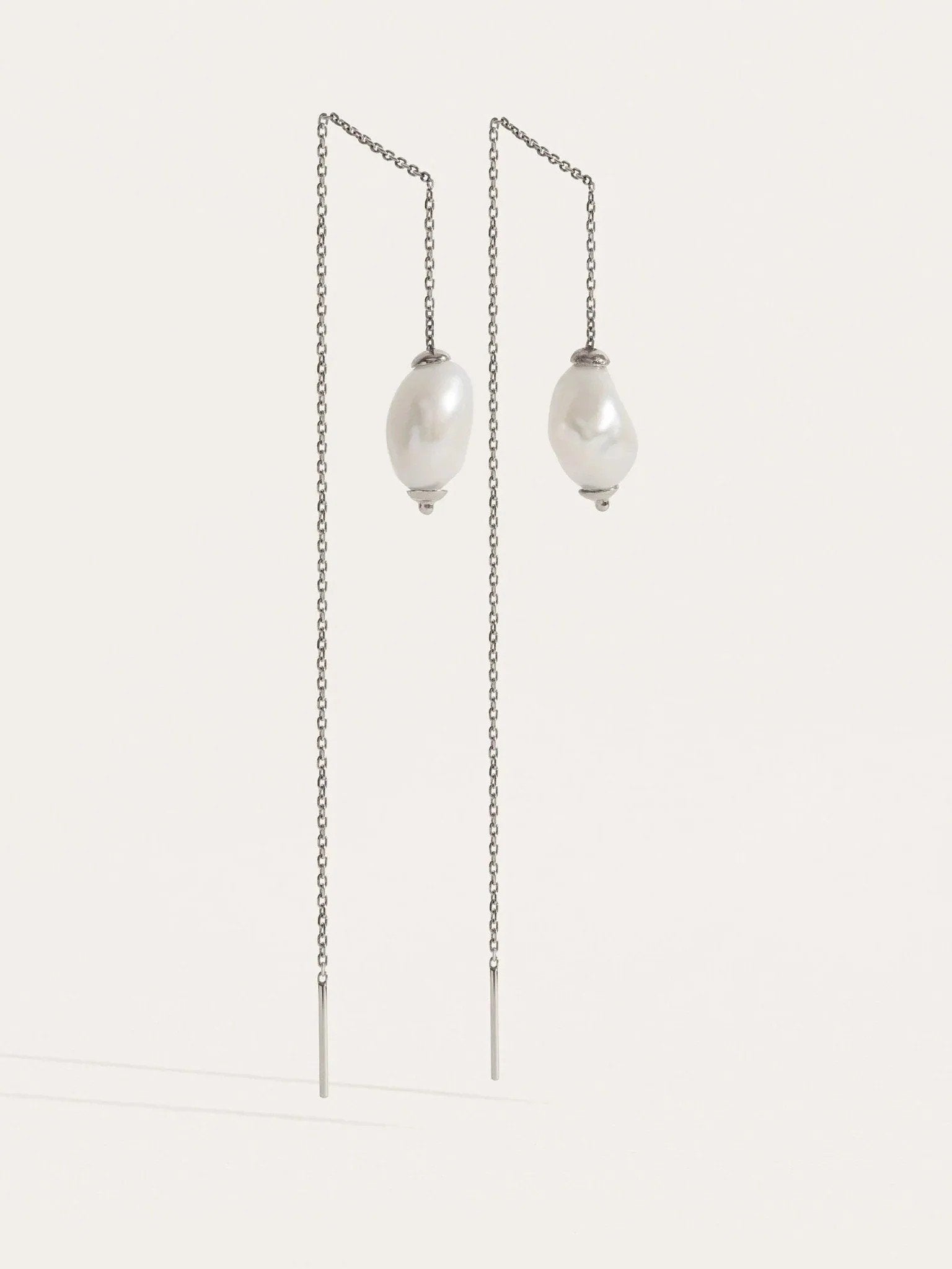 Front-facing view of threader earrings in sterling silver — minimalist chain with freshwater pearls.