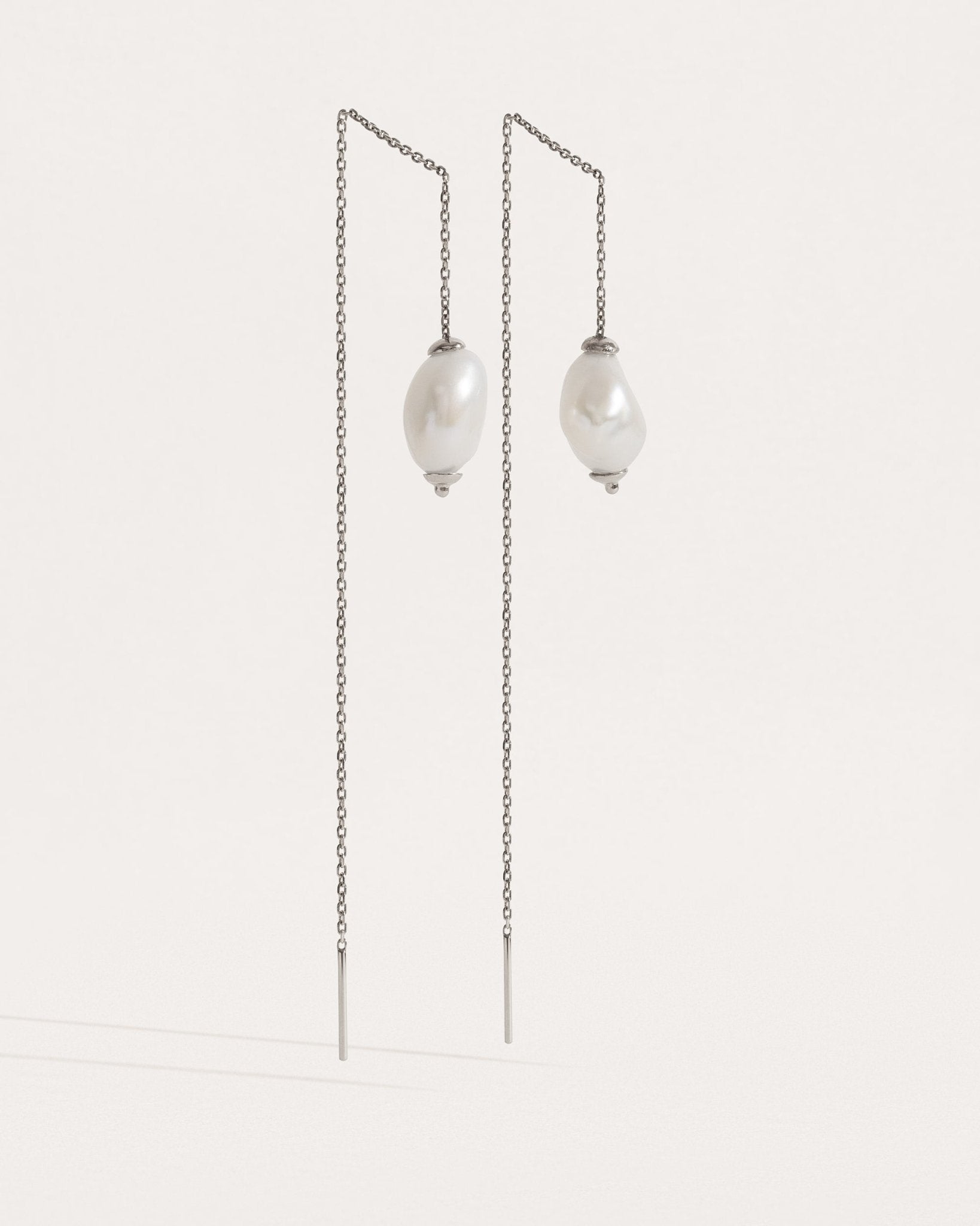 Front-facing view of threader earrings in sterling silver — minimalist chain with freshwater pearls.