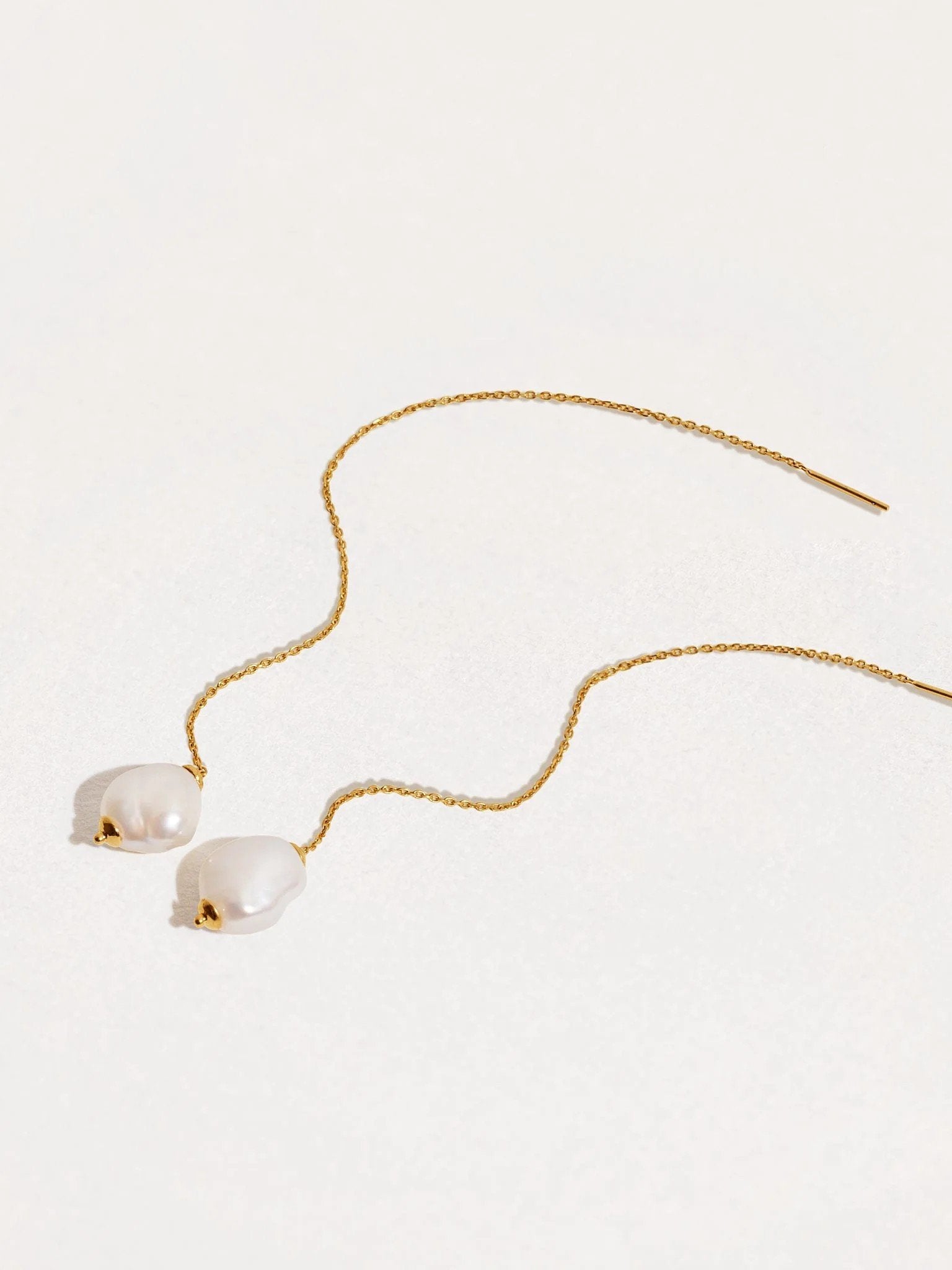 Pair of long threader earrings with freshwater pearls and 24K gold plated chain — elegant and minimal design on white background.