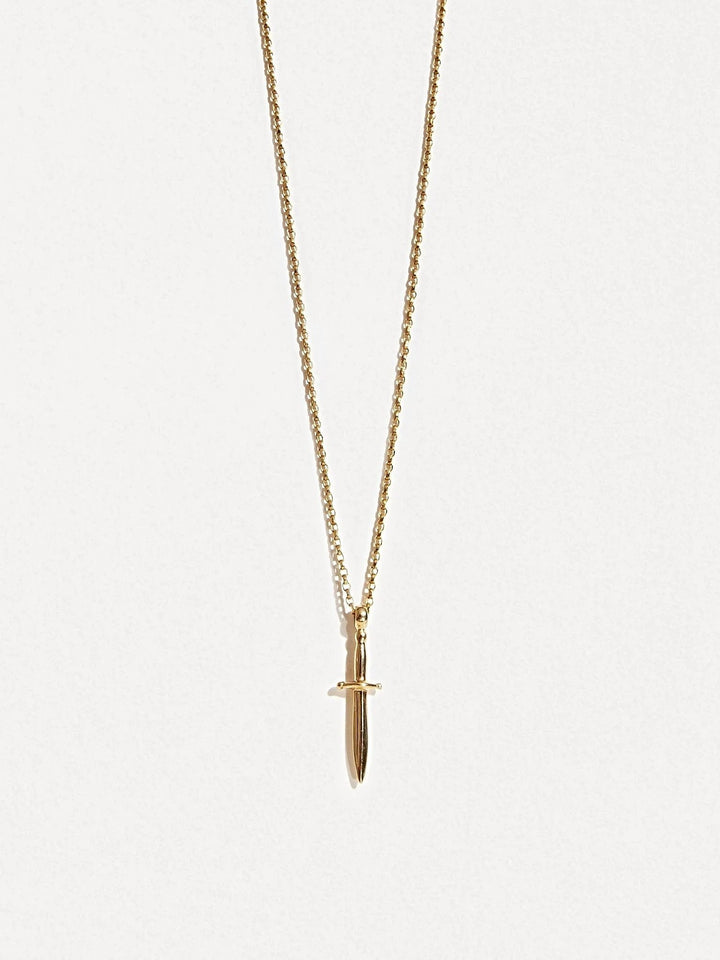 Gold dagger necklace on white background, front-facing product shot.