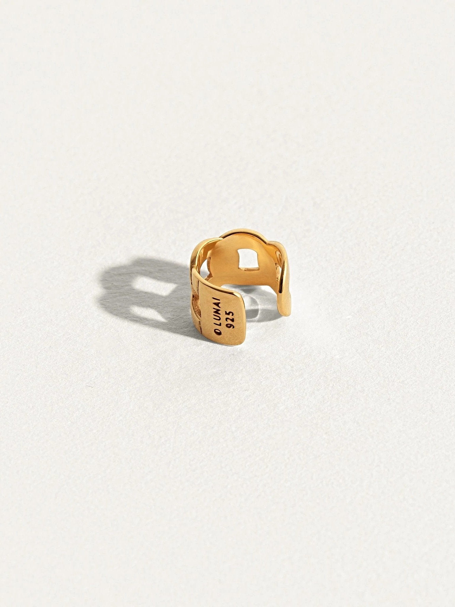 Gold Renatte chain ear cuff — minimalist structure with soft shadow on clean backdrop.