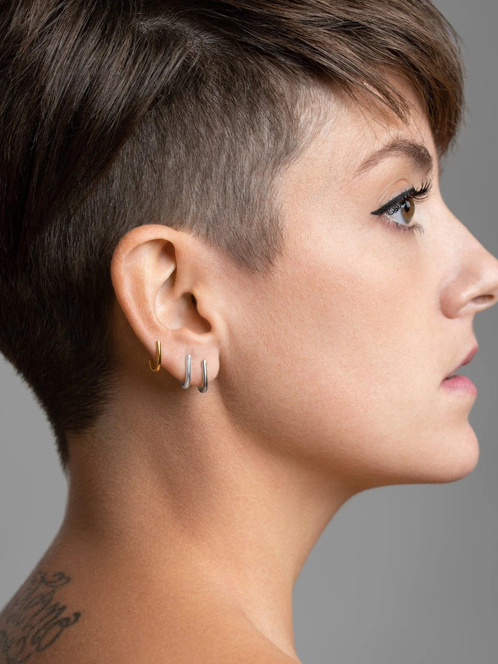 Sita bar earring in 24K gold plated finish — geometric minimalism styled on ear.