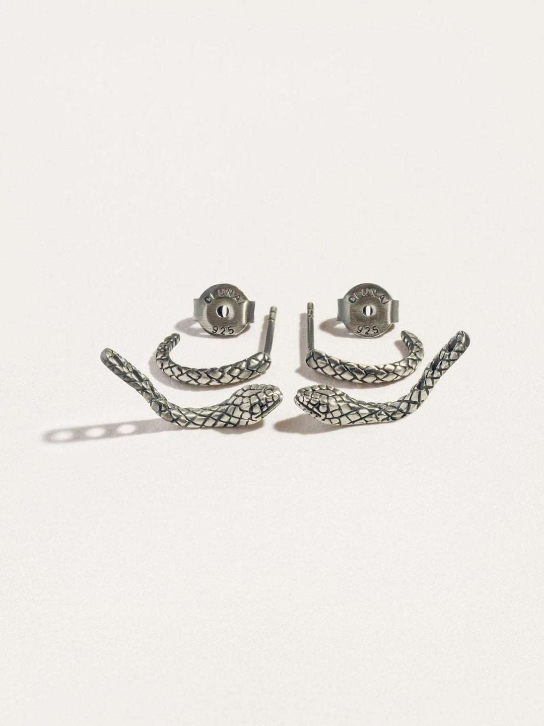 Sterling silver raw snake ear jacket set, laid out on a white surface with intricate details.