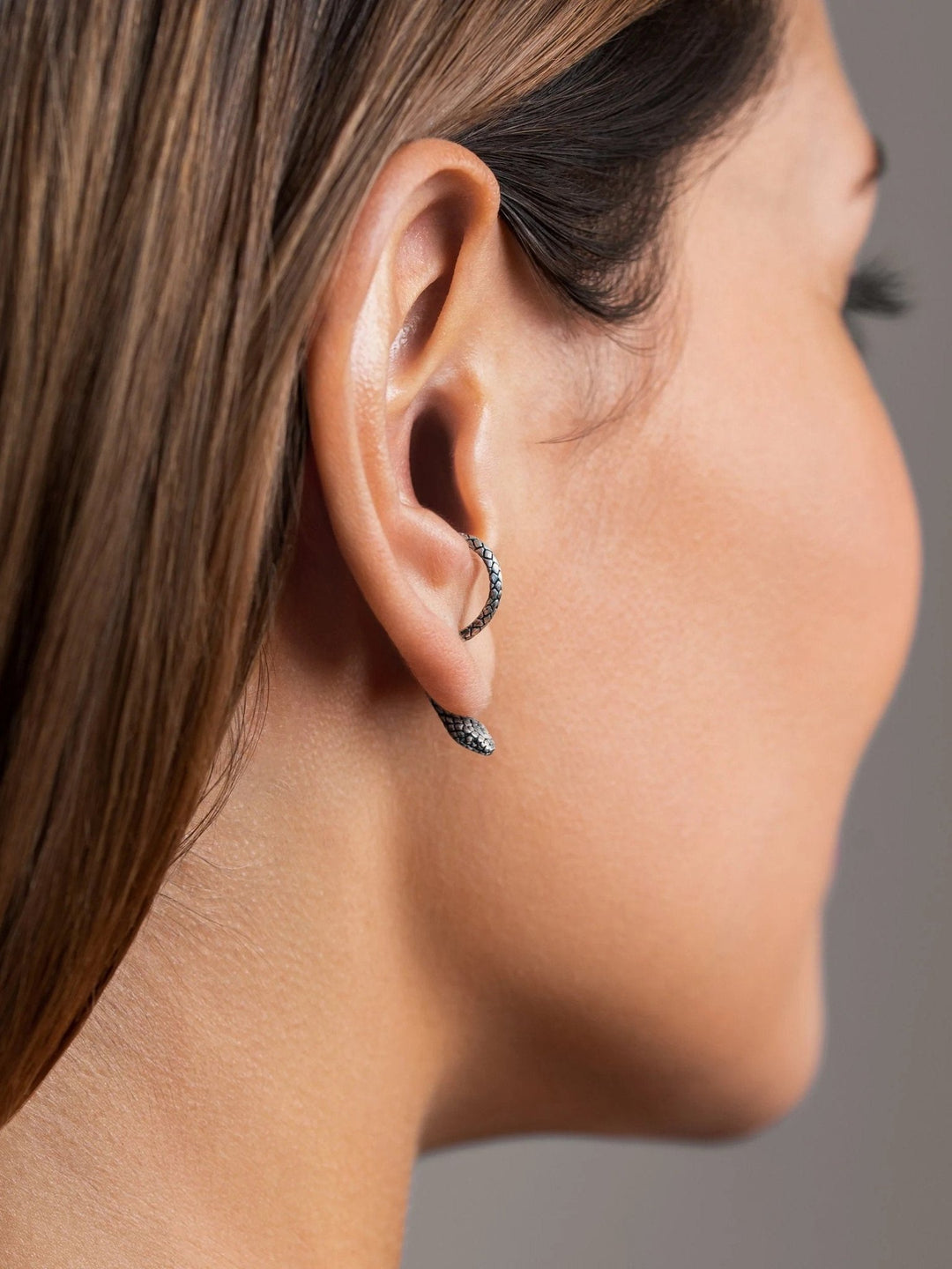 Sterling silver oxide snake ear jackets worn by a model, side view for fit and contrast.