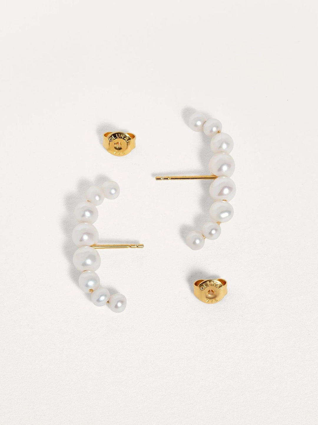 Pair of handmade pearl ear cuffs in sterling silver with 24k gold plating, displayed on a neutral background.