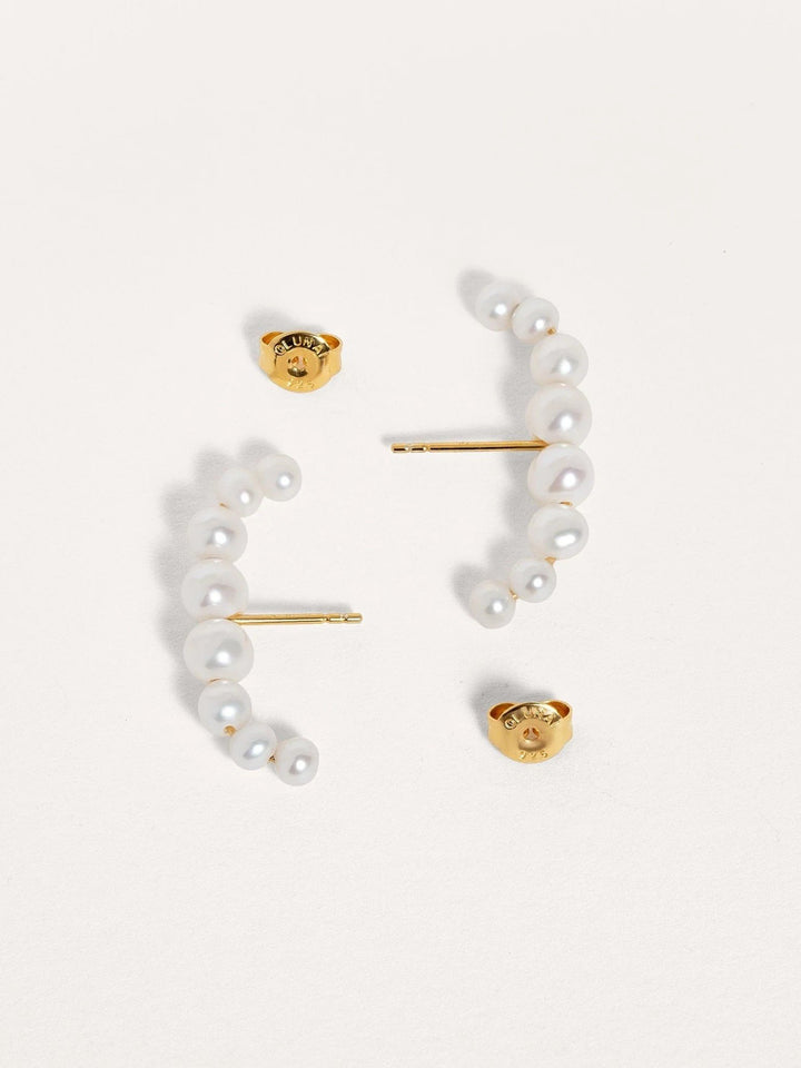 Pair of handmade pearl ear cuffs in sterling silver with 24k gold plating, displayed on a neutral background.
