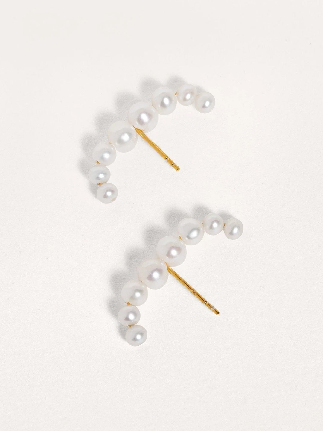 Side view of the Solene ear cuff highlighting the curve and pearl accent on gold-plated sterling silver.