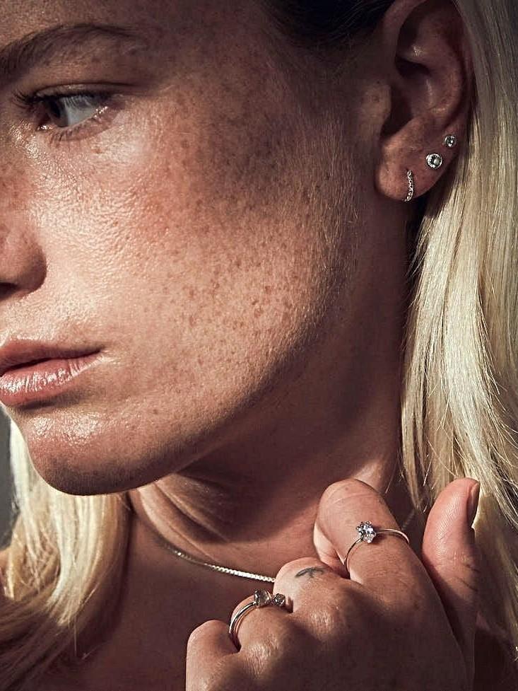 "Model showcasing jewelry with natural light and soft focus"