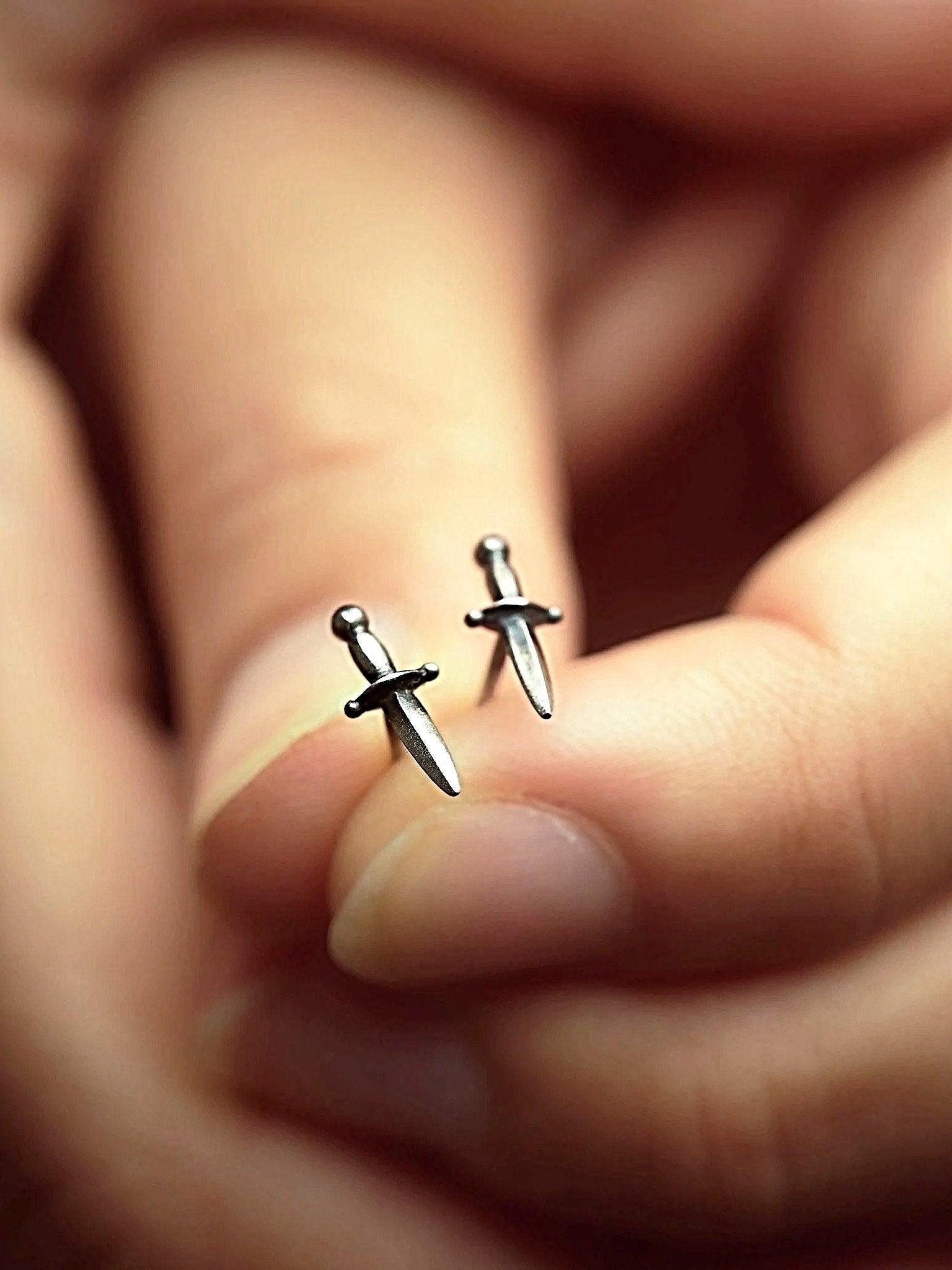 Hand holding Tessa Sword Stud Earring in Sterling Silver – Minimalist and sophisticated