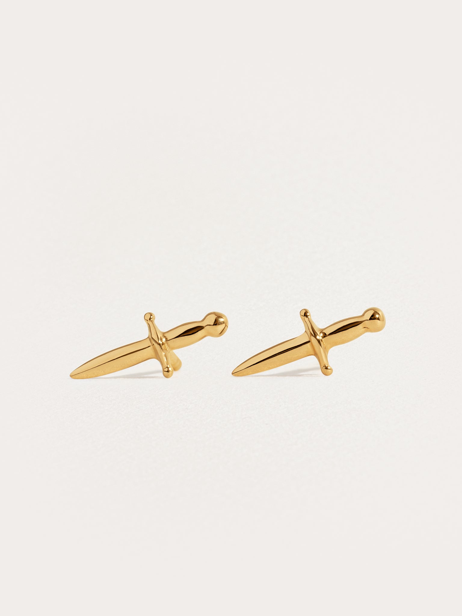 Tessa Sword Stud Earrings in 24K Gold Plated – Minimalist dagger earrings on white background"