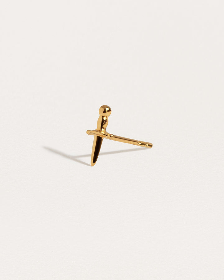 Gold-plated Tessa Sword Stud Earrings held in hand for size reference"