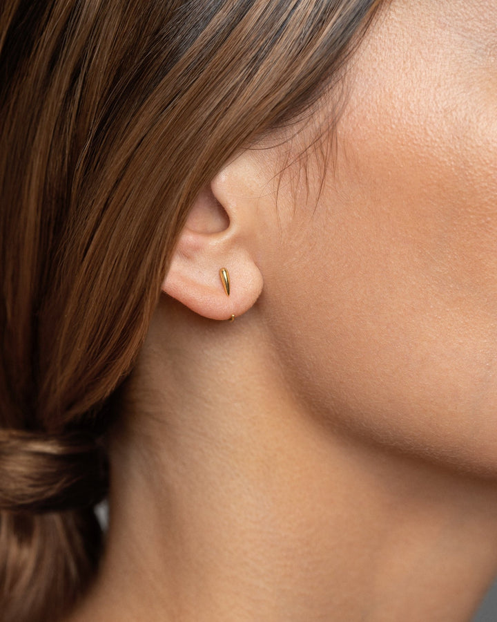 Side view of Luppa gold hug hoop earring — minimalist and sculptural fit.