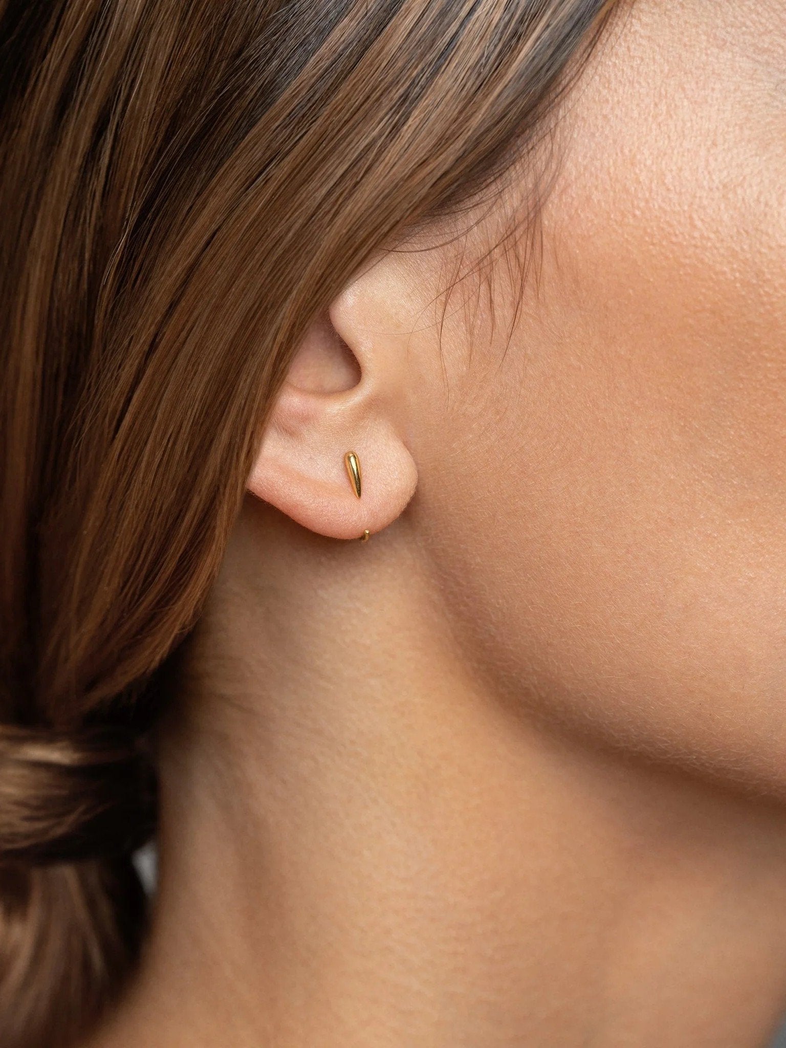 Side view of Luppa gold hug hoop earring — minimalist and sculptural fit.