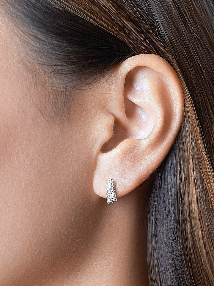 Close-up of model wearing silver tassel drop earrings