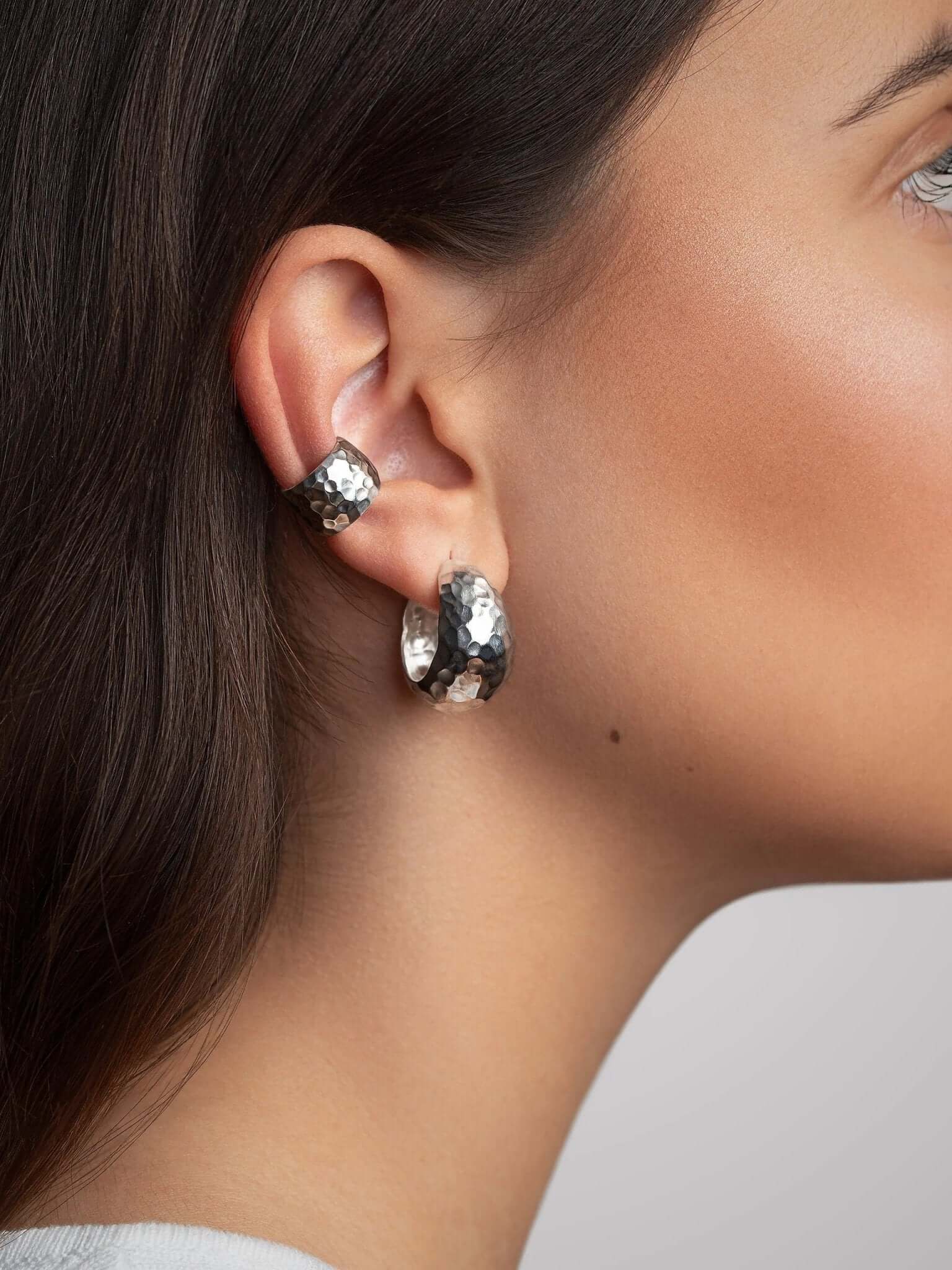 Silver conch cuff earring worn on upper ear with hair tucked back, showing comfortable and secure fit.

