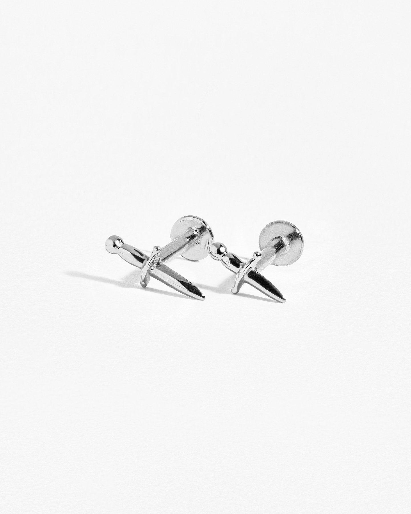 Front view of sterling silver dagger earring on clean white backdrop