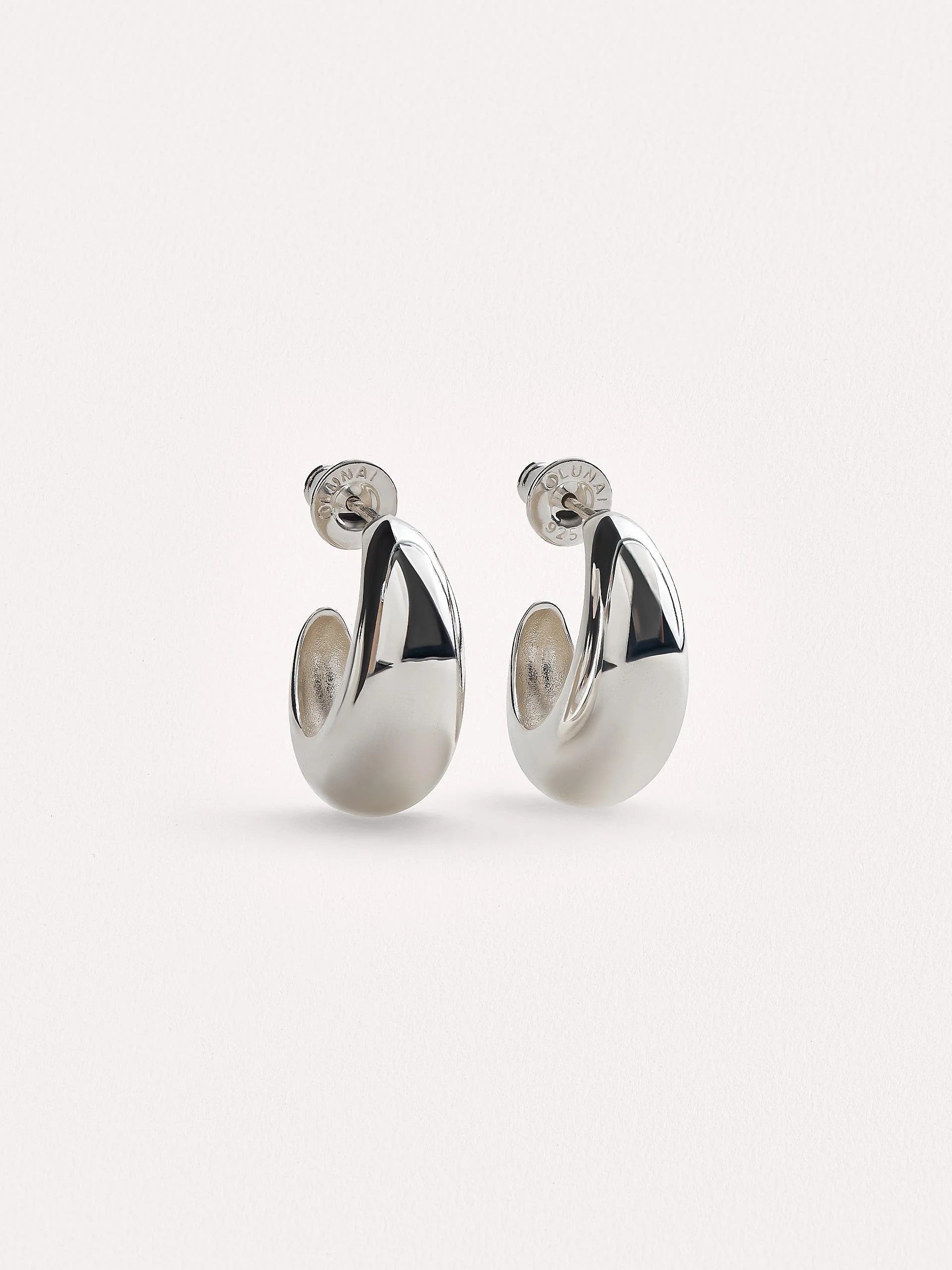 Silver plated petite crescent hoop earrings with sterling silver posts, shown against a clean light background.