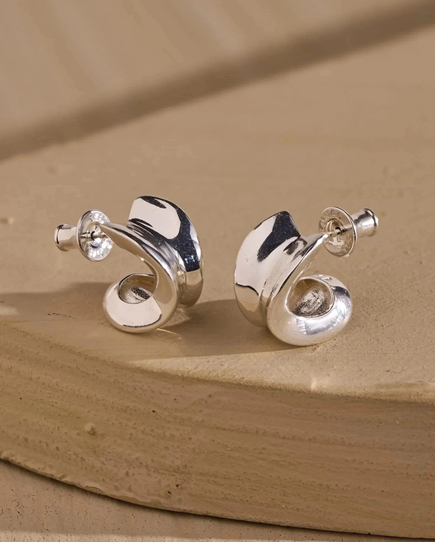 Silver plated chunky hoops shown from an angled view highlighting their smooth reflective finish.