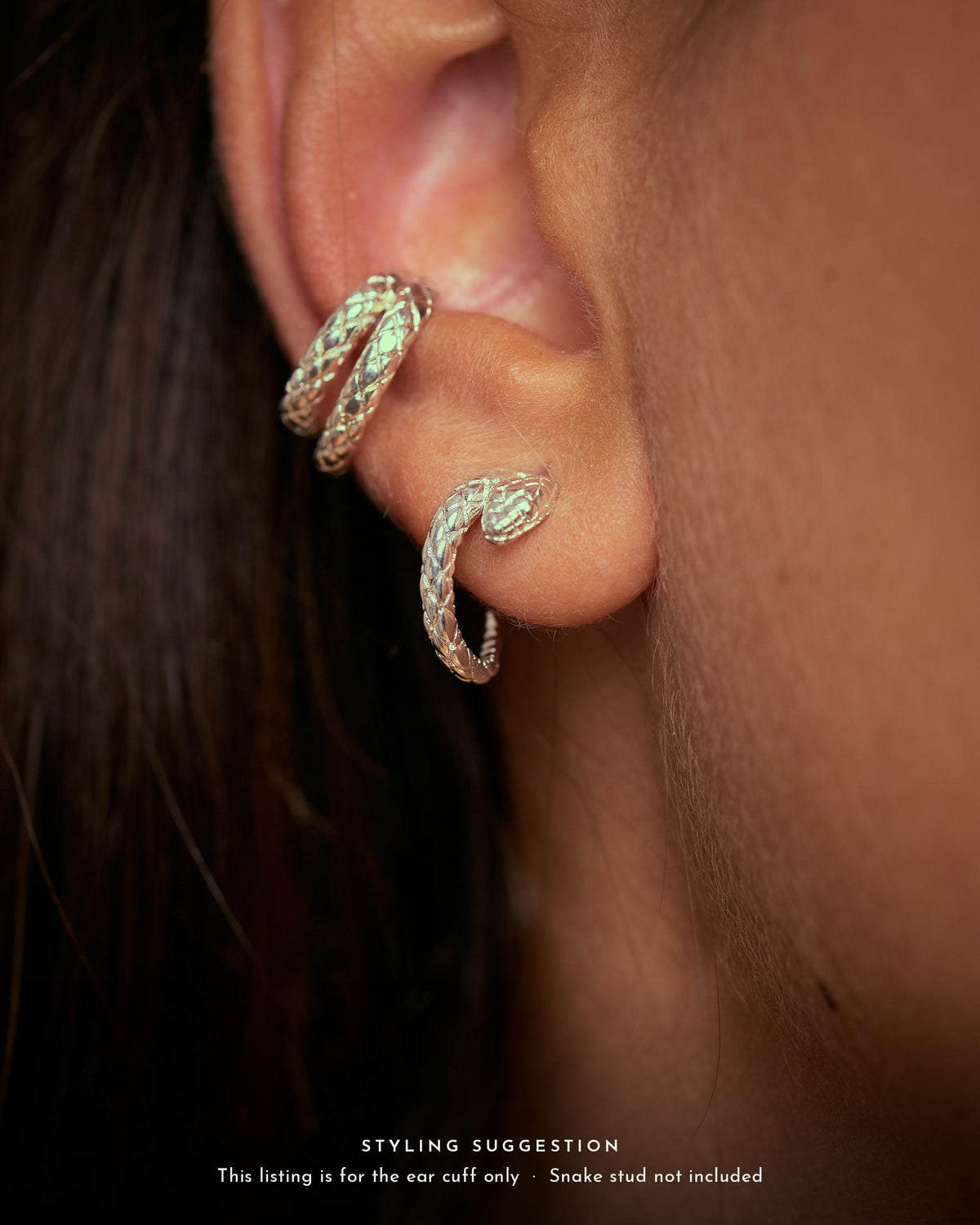 Sterling silver plated brass snake ear cuff worn on the conch, styled with a matching snake stud on the lobe. Ear cuff sold alone.