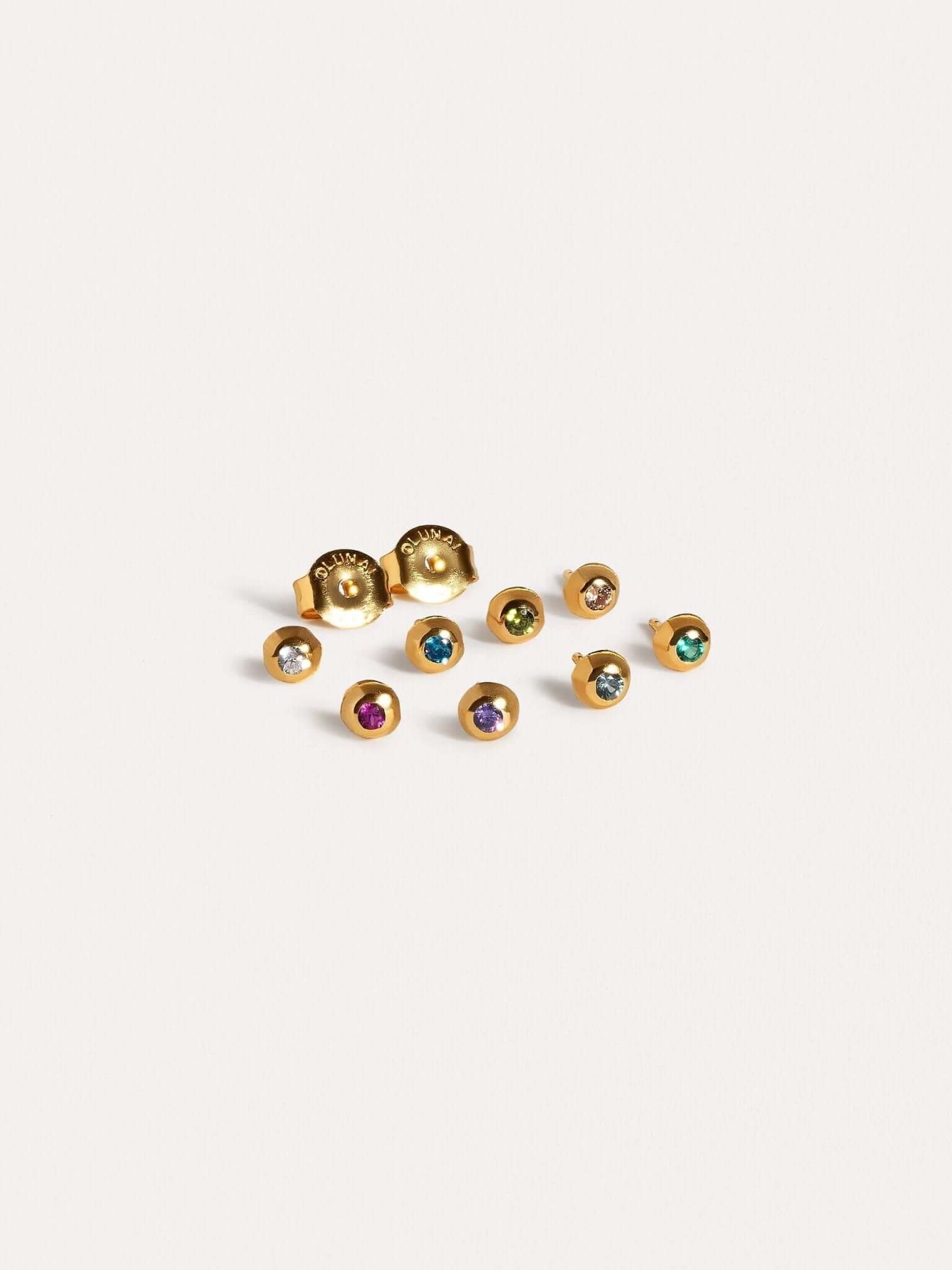 Set of gold stud earrings with colorful gemstones in various shades.