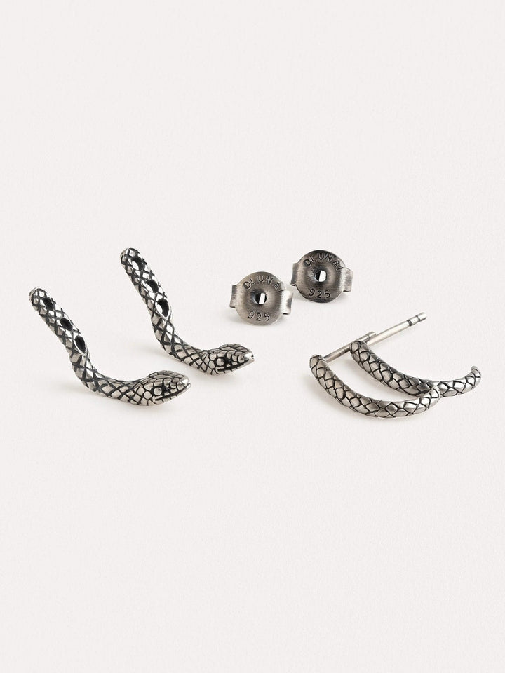 Close-up of an oxidized silver snake hoop earring on an ear, highlighting its textured details and unique shape.
