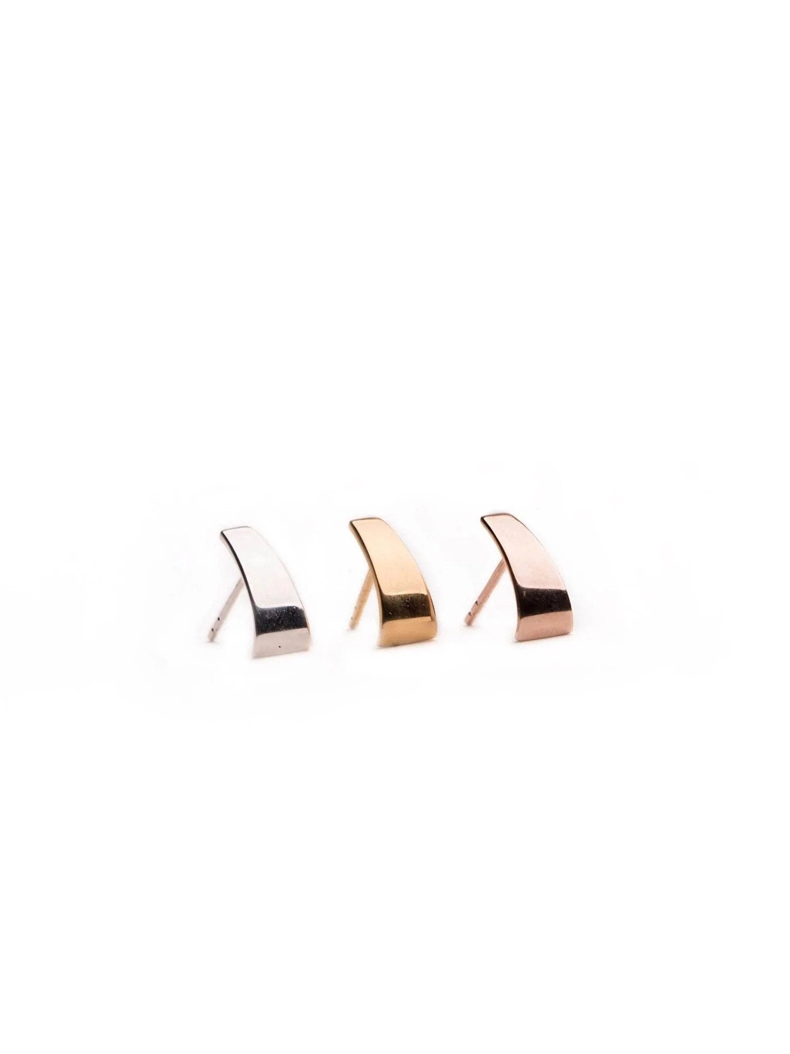 Set of Terita minimalist stud earrings in gold, silver, and rose gold — sculptural design on white background.