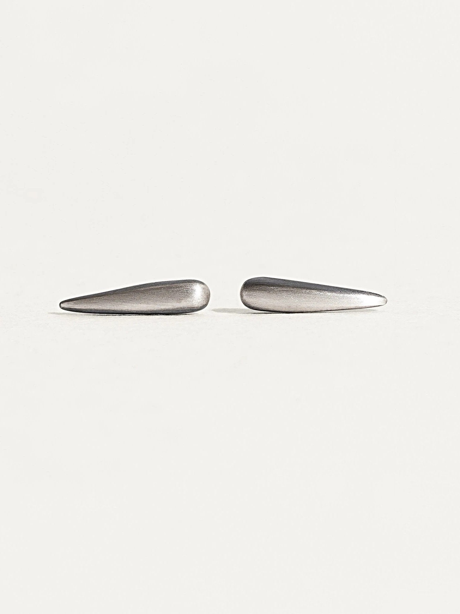  "Aura Dainty Tusk Earrings in silver on neutral background"