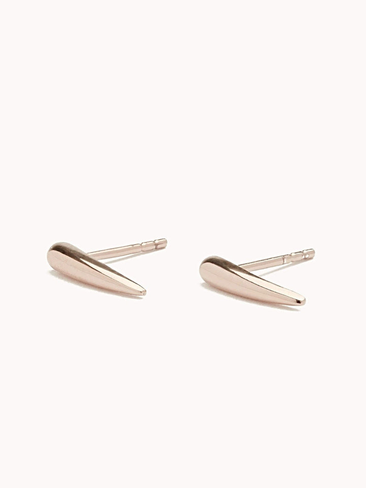 "Aura Dainty Tusk Earrings in rose gold on neutral background"