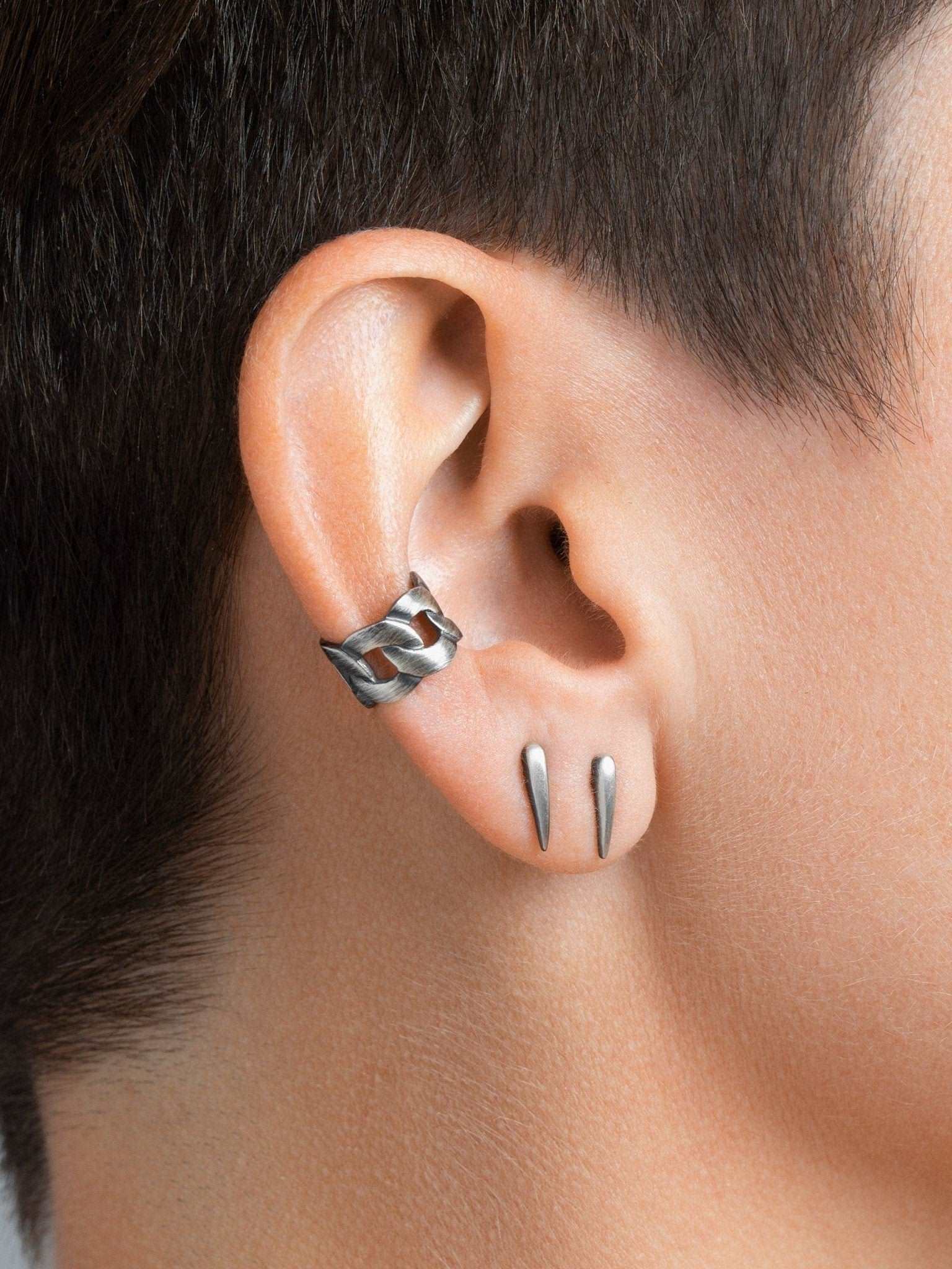 "Model wearing Aura Dainty Tusk Earrings in silver oxide with soft lighting"