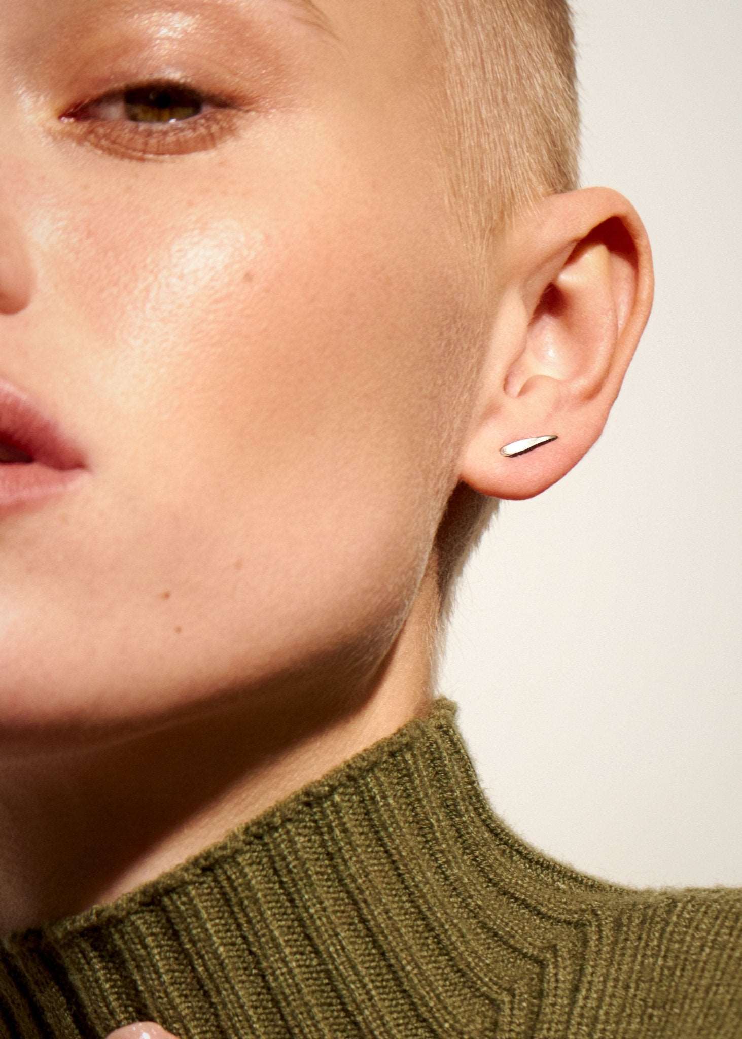 "Model wearing Aura Dainty Tusk Earrings in silver, side view"