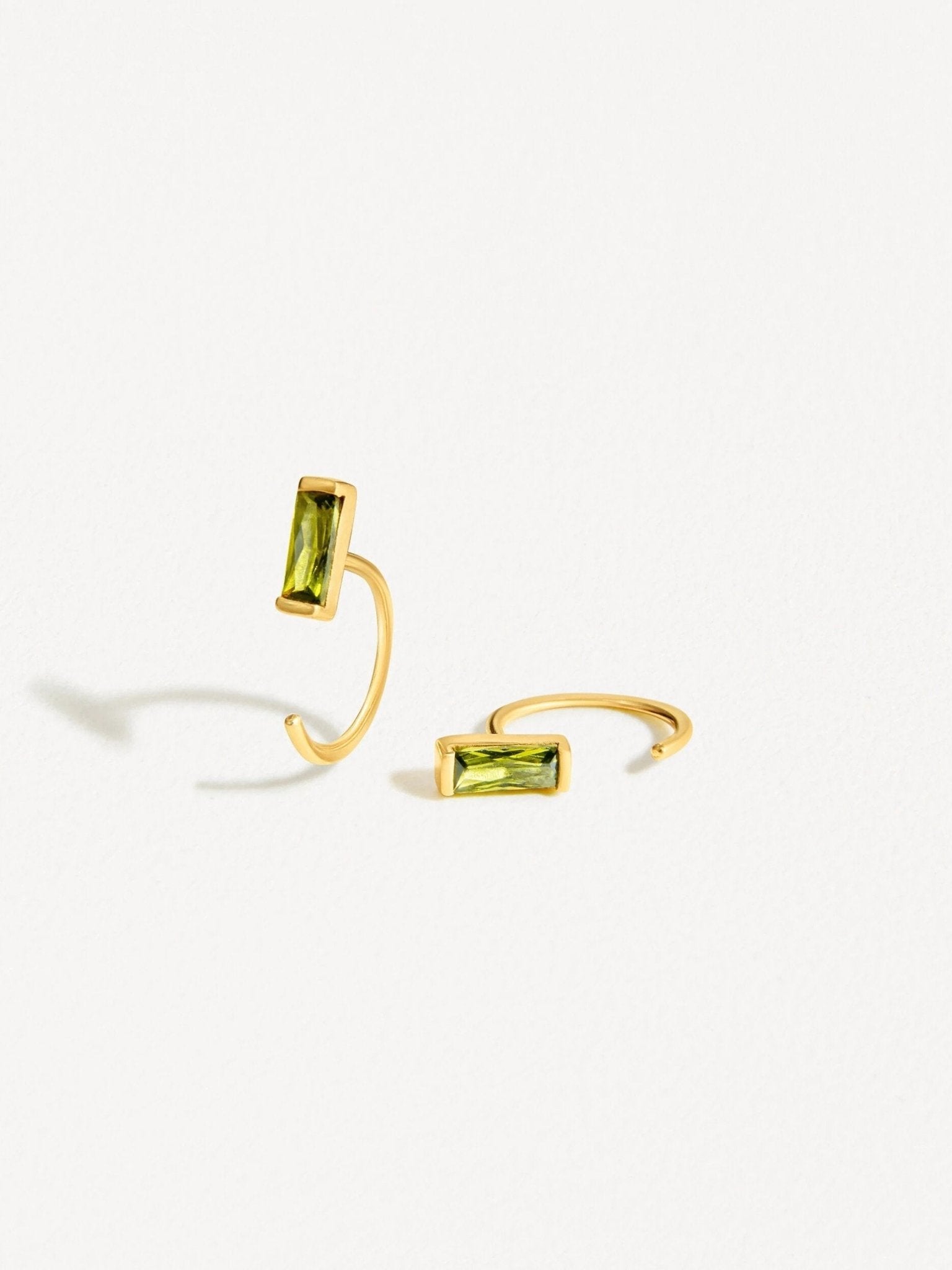 Gold peridot open hoop earrings, featuring a bar-set gemstone for a modern and refined style.