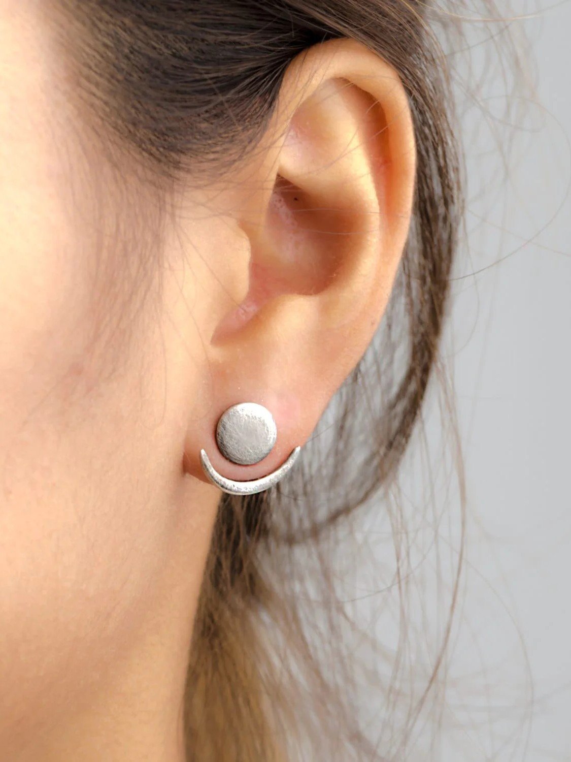 Sterling silver oxide ear jackets, close-up on a model with braided hair.