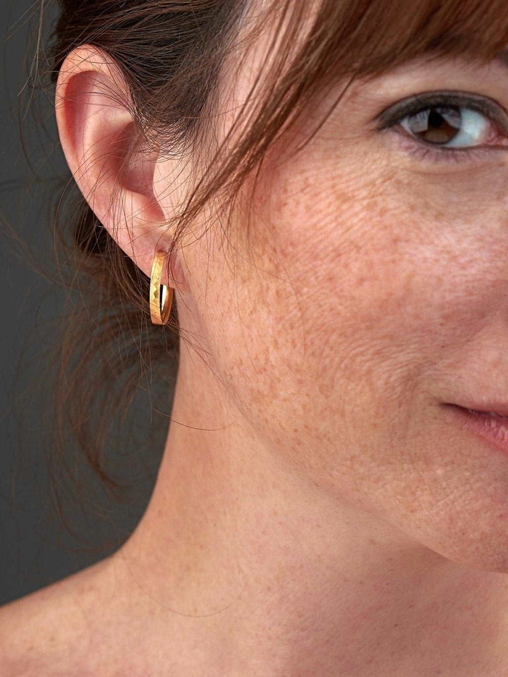 Model wearing medium hammered 24K gold matte hoop earrings – timeless and sophisticated design
