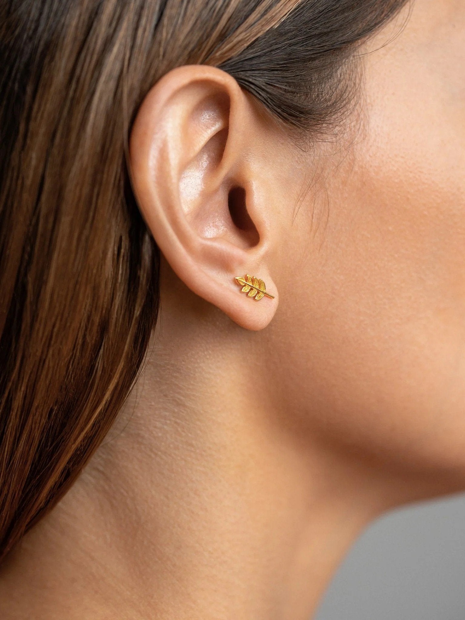Gudrun leaf earrings in gold worn — minimalist and nature-inspired elegance.