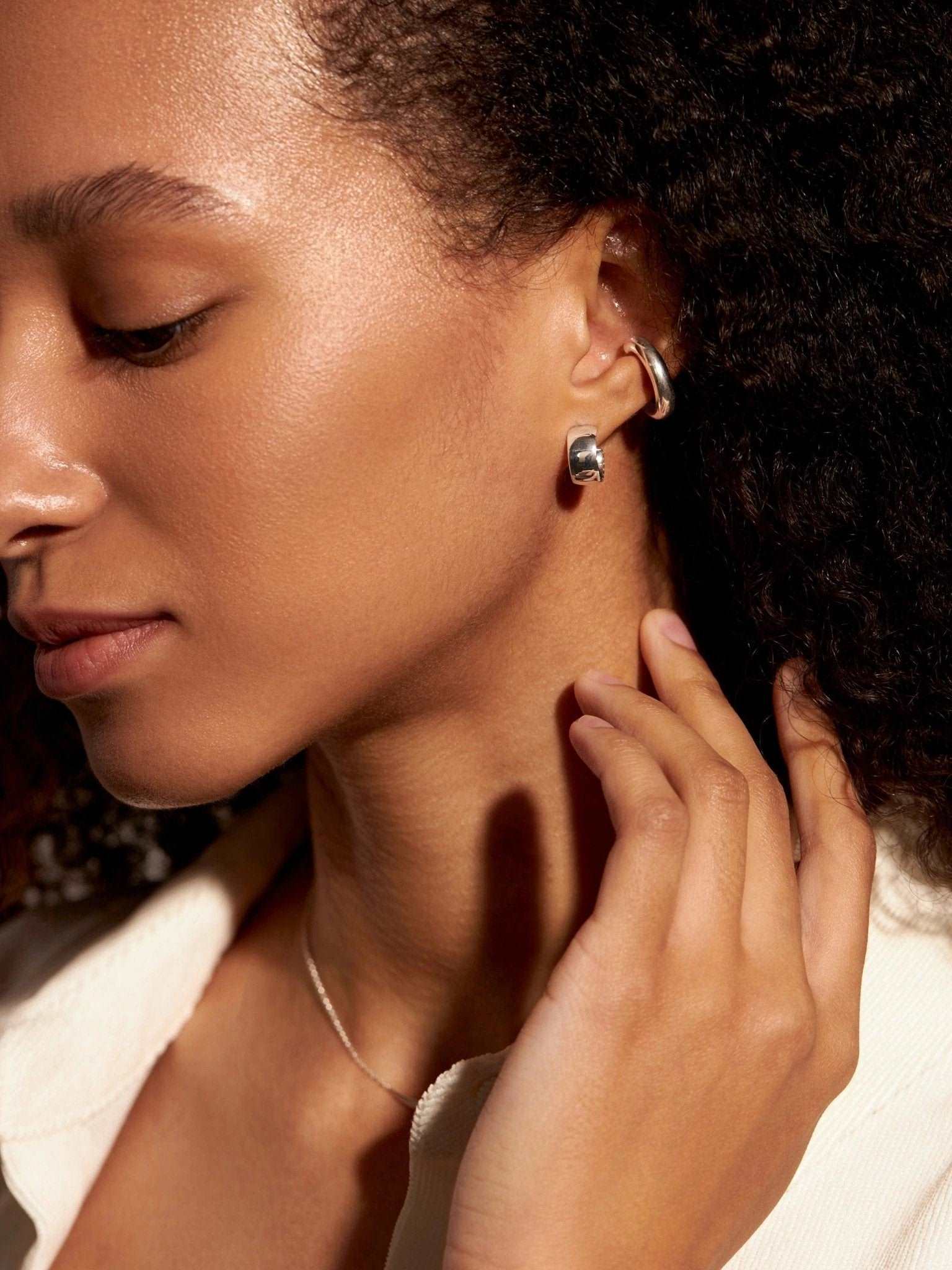 Elegant portrait of model wearing  sterling silver hoop earrings.
