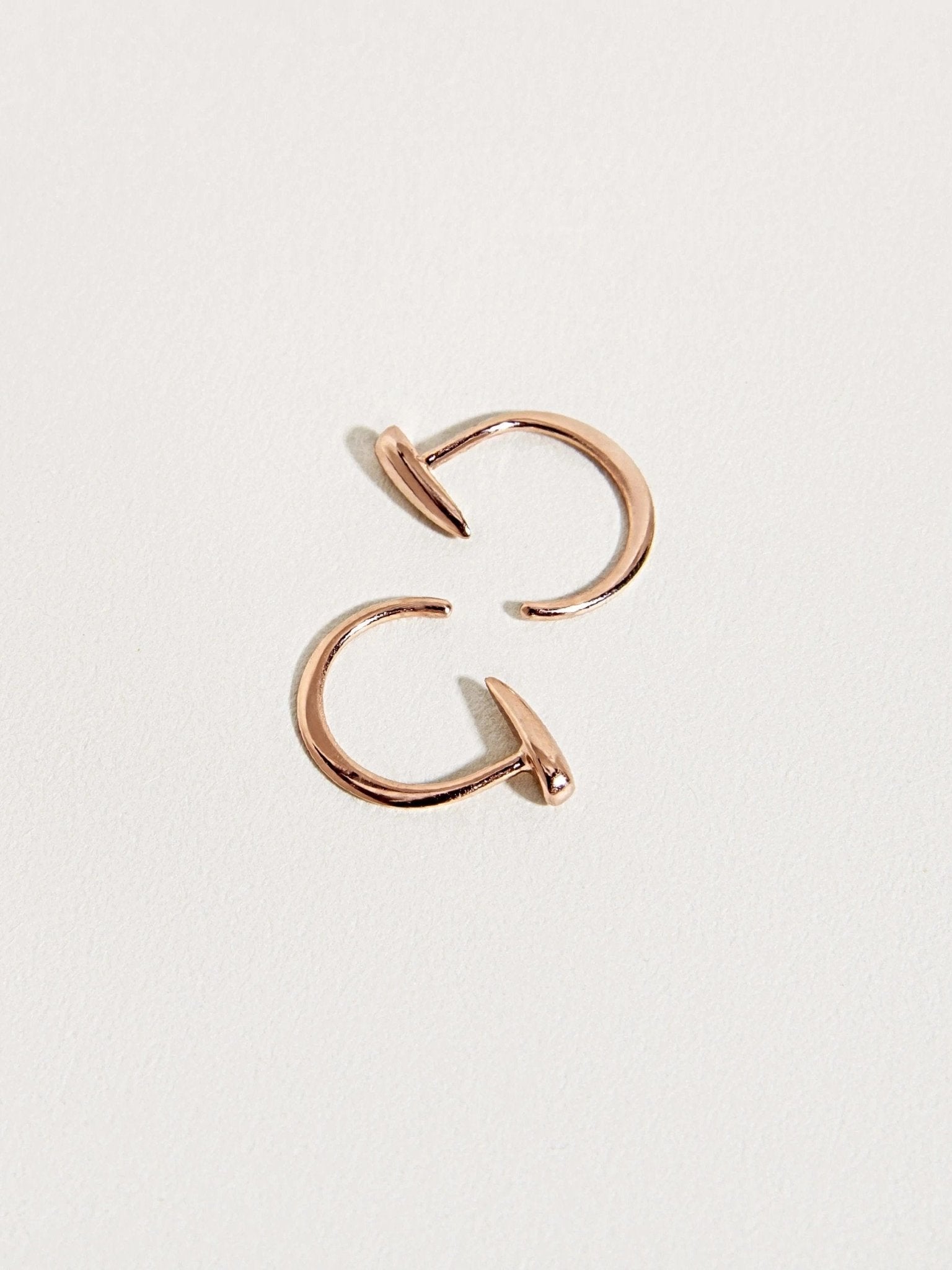 Luppa gold hoop earrings with curved open design — tusk-inspired silhouette.
