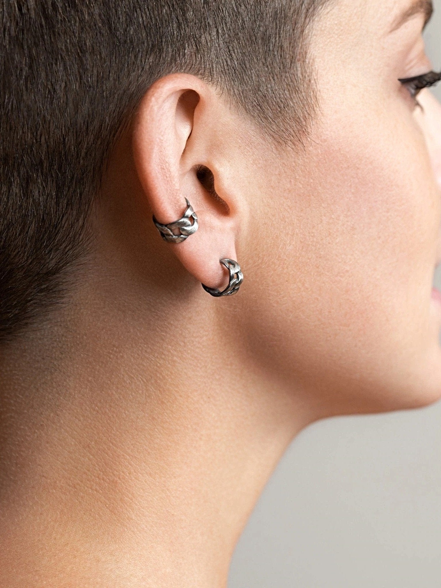 Close-up of Meel Gold Hoop Earrings catching the light on a short-haired model — a bold statement in silver oxide