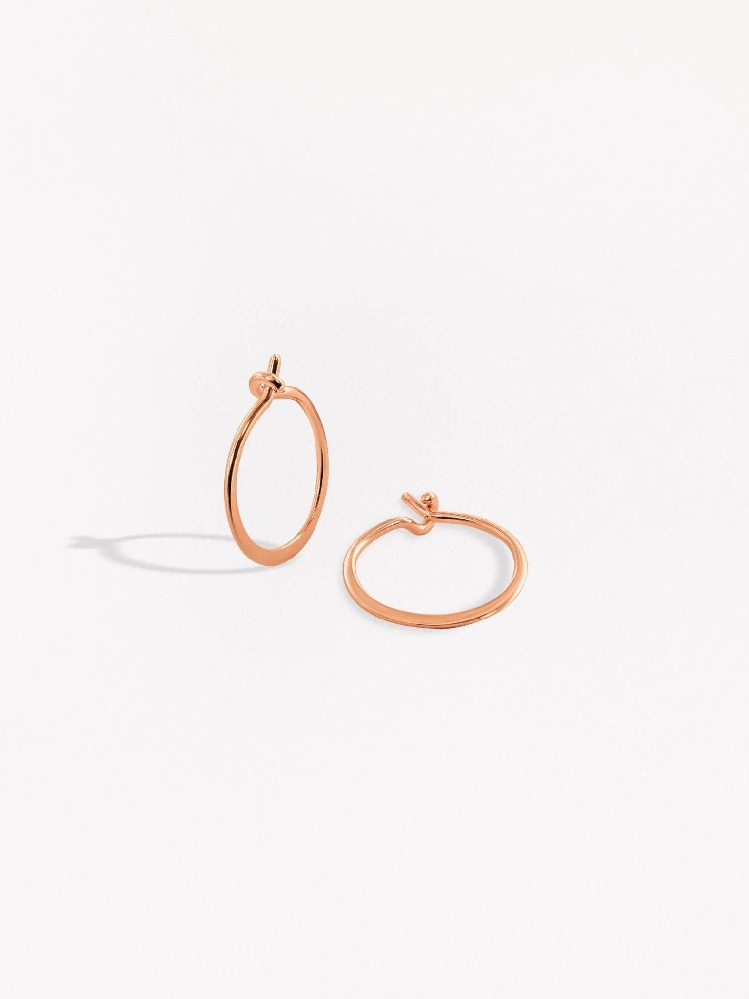  Rose gold hoop earrings with a modern open shape on a white background.