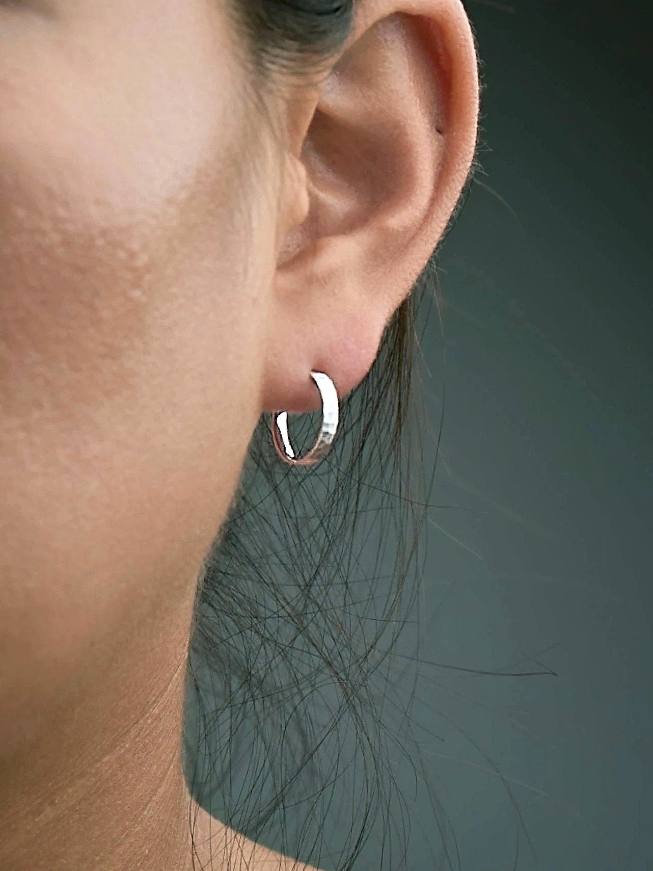 Nanna matte sterling silver huggie hoop worn on tragus — subtle texture and understated shine.