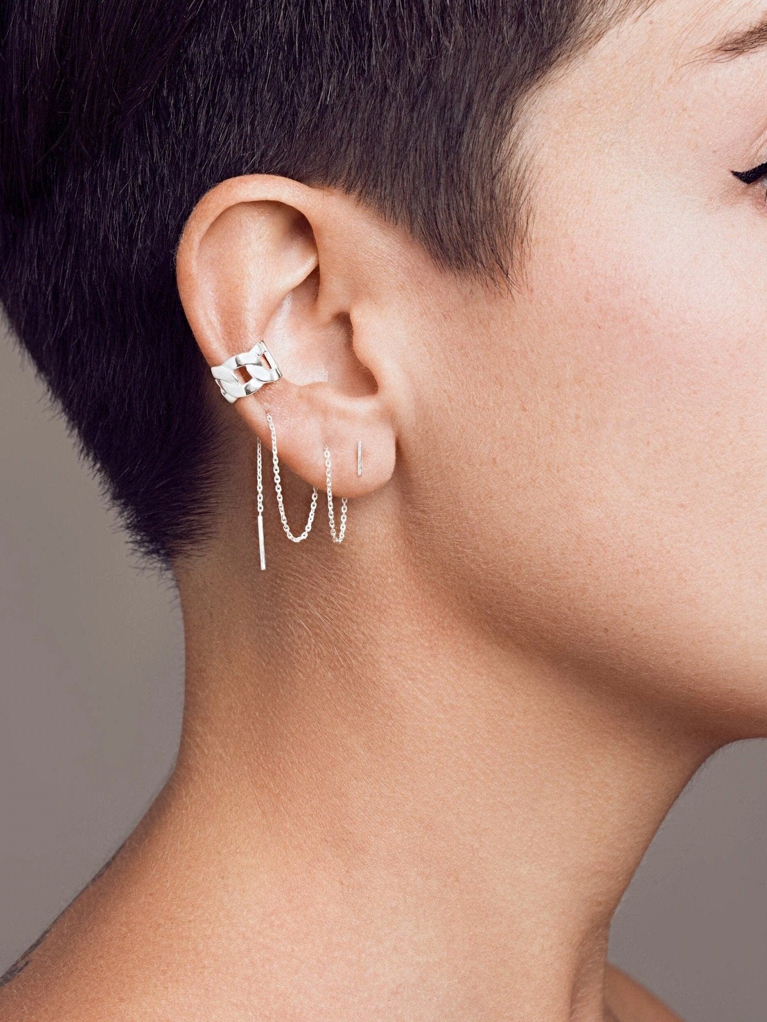Renatte gold ear cuff worn — statement look with modern short haircut.
