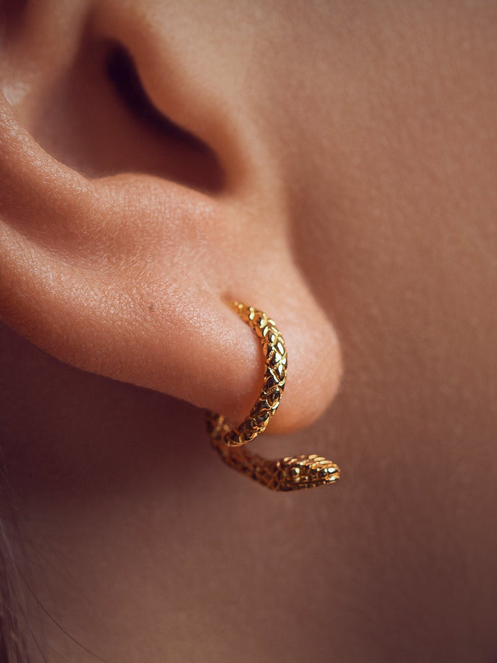  Close-up of the 24K gold plated snake ear jacket, highlighting its sleek curves and refined texture.