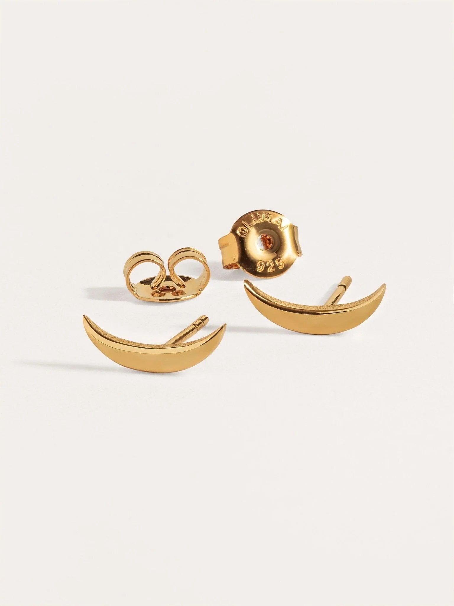 Three-piece gold crescent stud earring set on white background