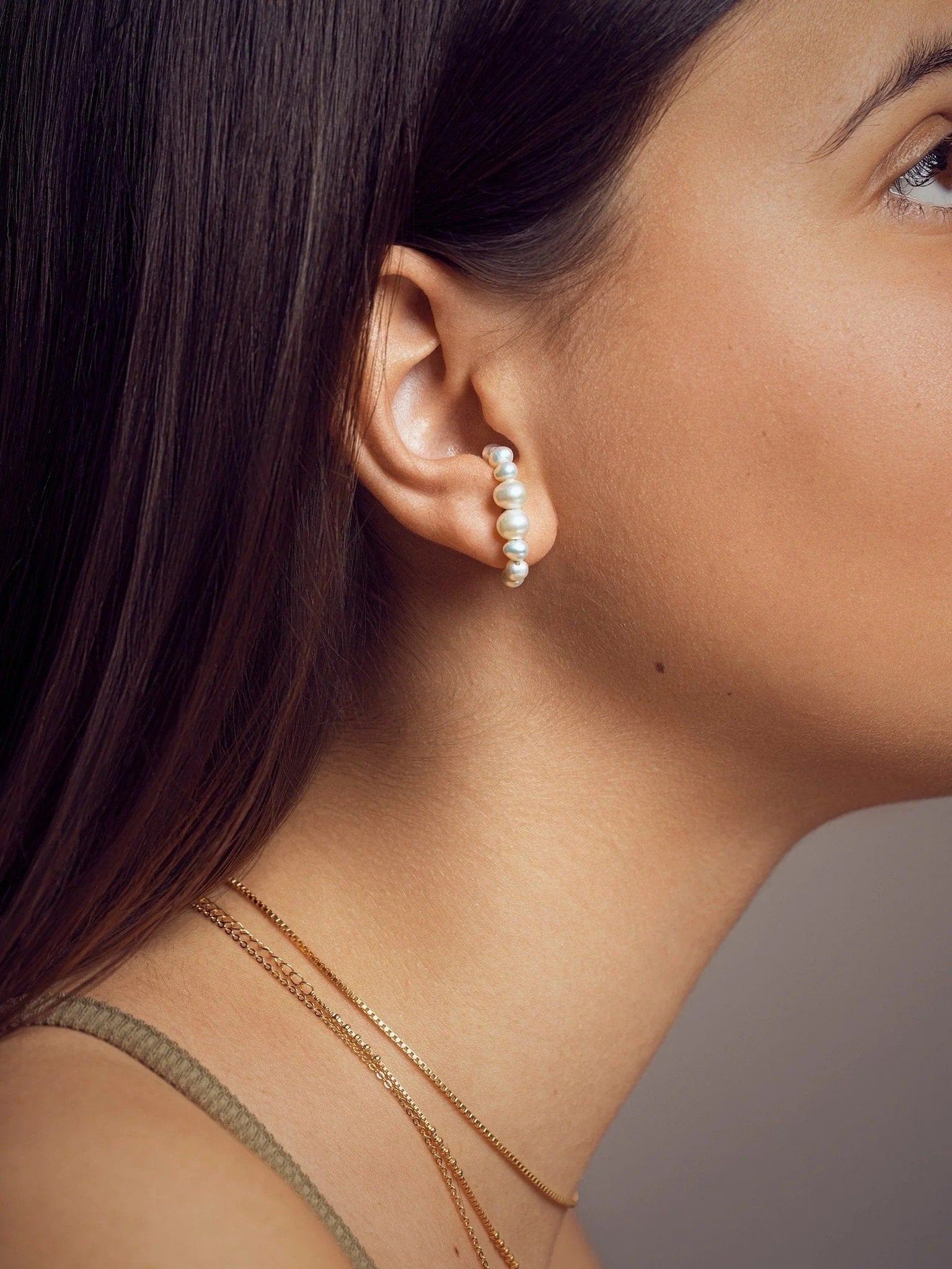 Lifestyle photo of model wearing the Solene ear cuff in a natural setting, evoking calm and effortless elegance.