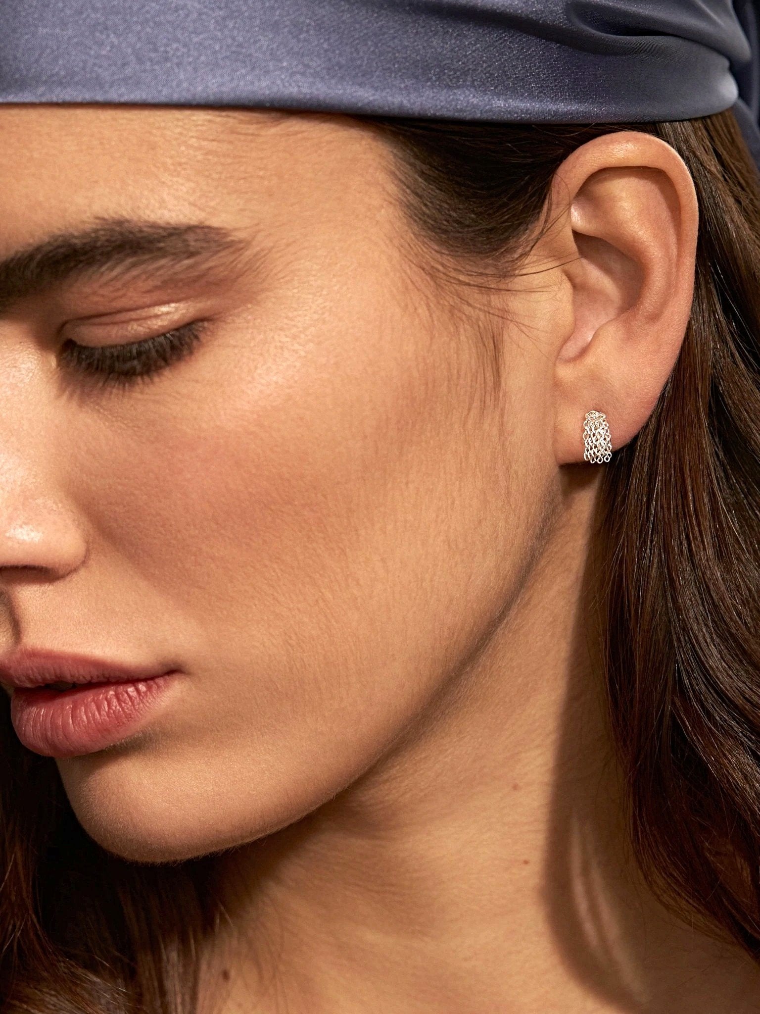 Side view of model wearing silver tassel drop earrings